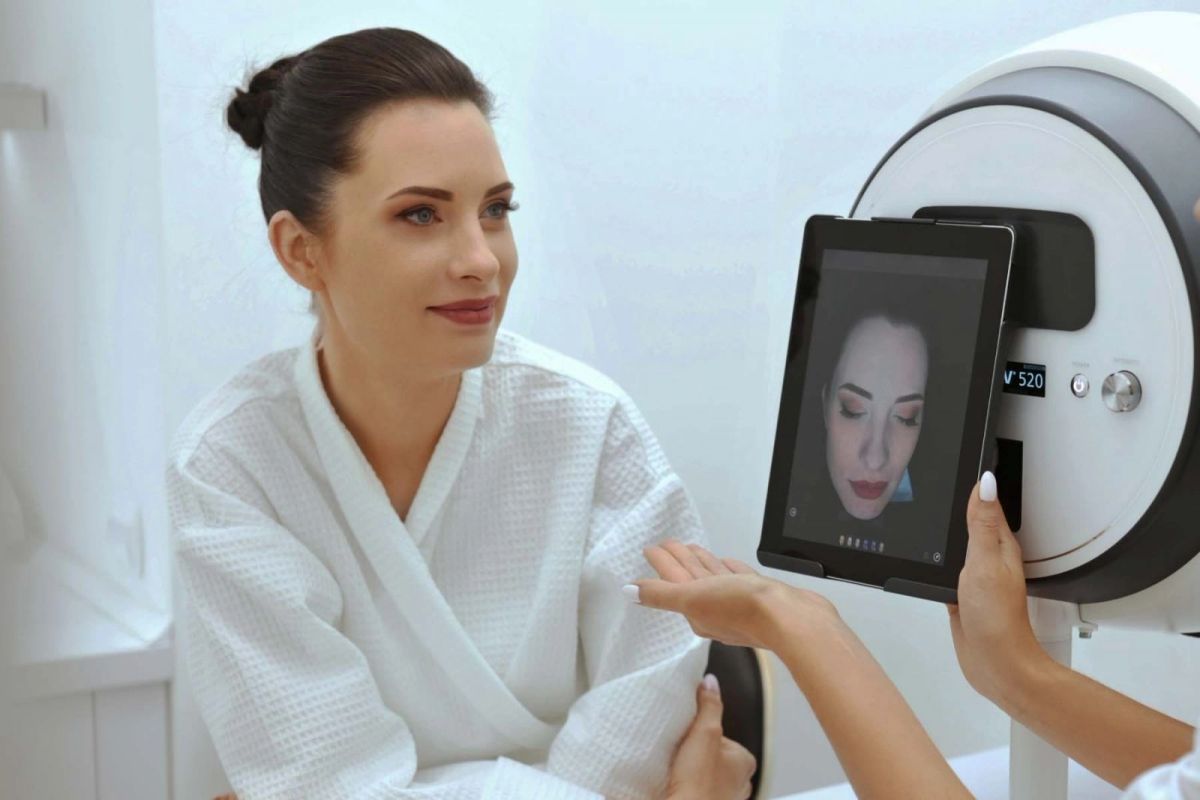 Practitioner presenting skin analysis results to a client on a device screen